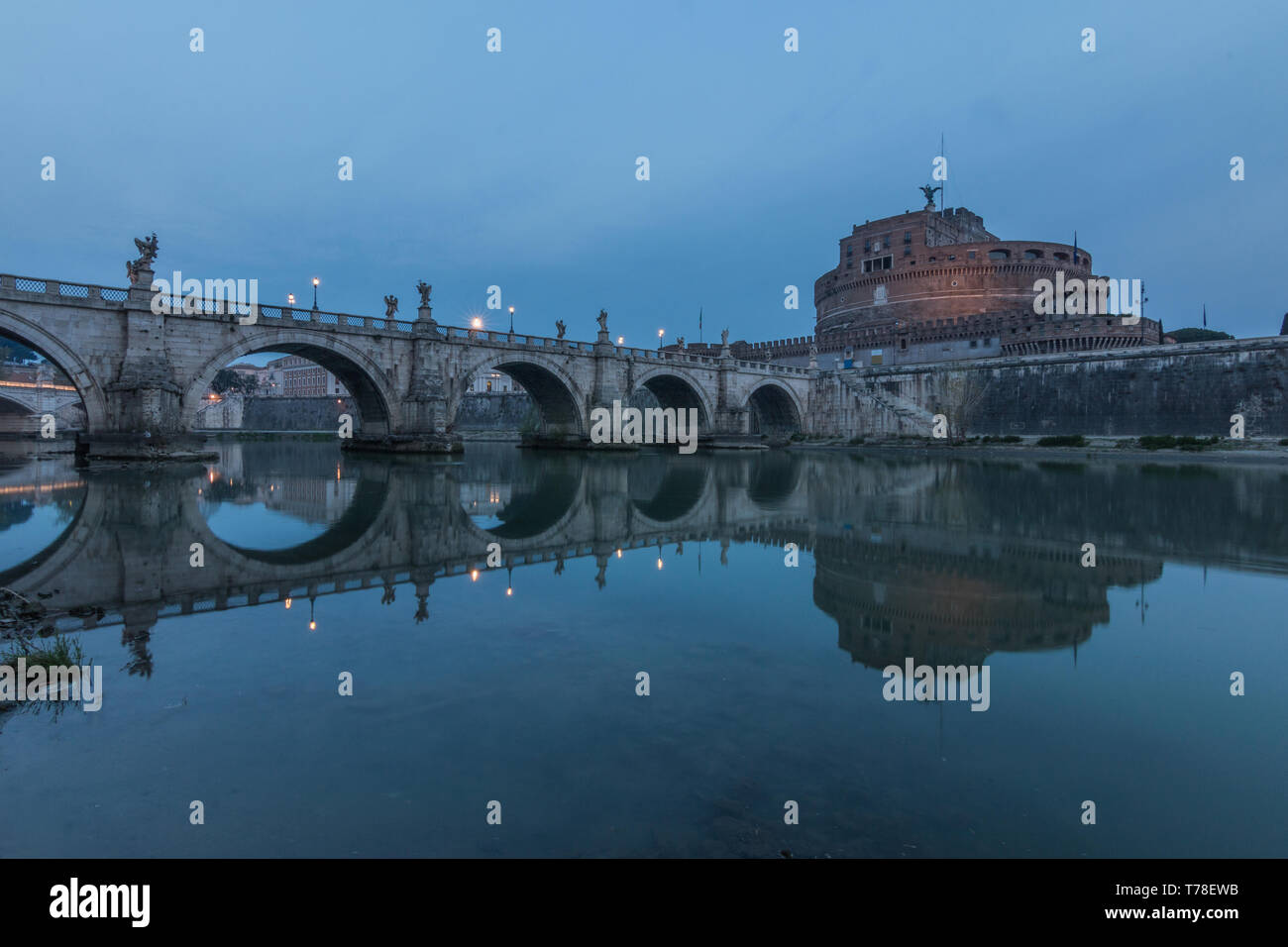 Tiber mit dem Aurelius Brücke über Wasser mit Schloss Sant Angelo im Morgen und blauer Himmel. Spiegelungen im Wasser von beleuchteten Gebäude Stockfoto