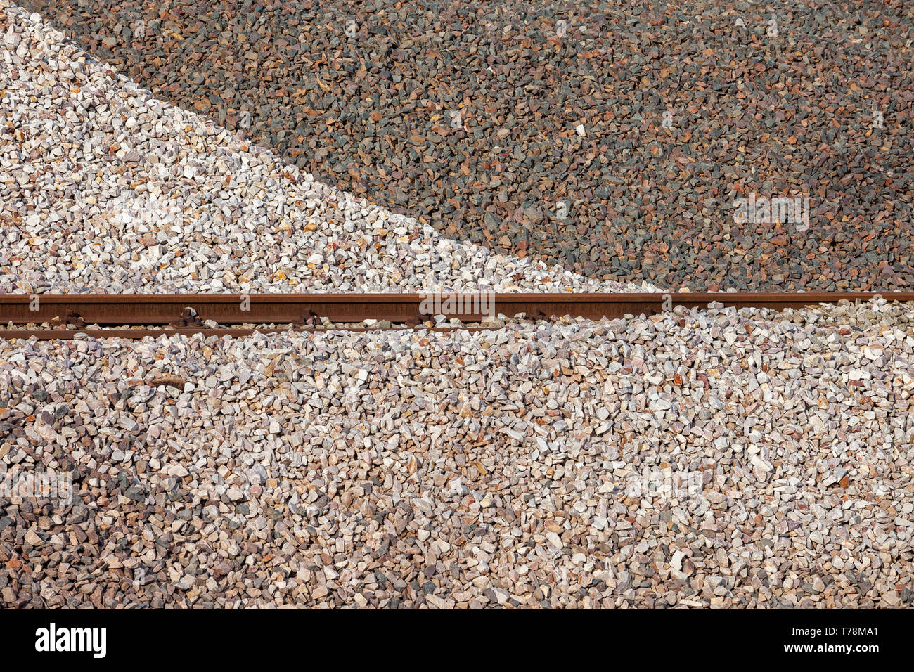Weiße und dunkle Schotter Pfähle Hintergrund mit Rail Trails in der Mitte Stockfoto