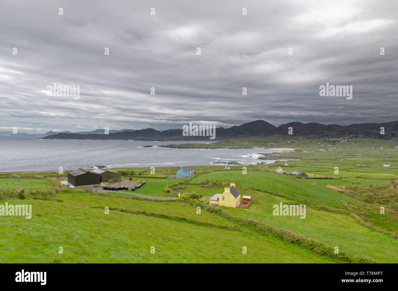 Blick auf Meer landwirtschaftliche Gebäude auf der schönen Ring of Beara im Südwesten Irlands, unter einem grauen Himmel Stockfoto