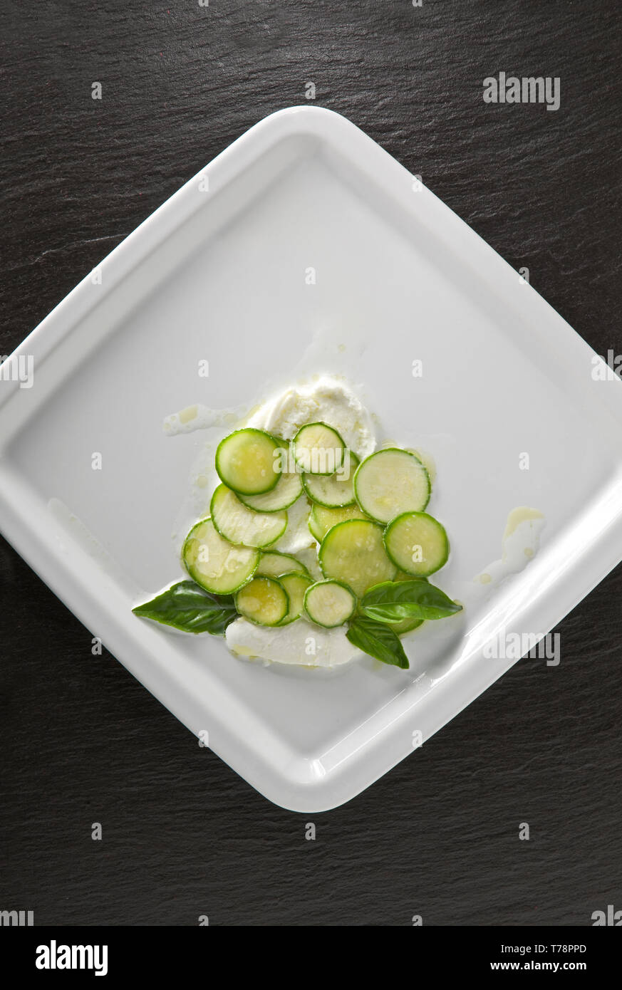 Un piatto con Mozzarella, basilico e zucchine. [ENG] eine Platte mit Mozzarella, Zucchini und Basilikum. Stockfoto