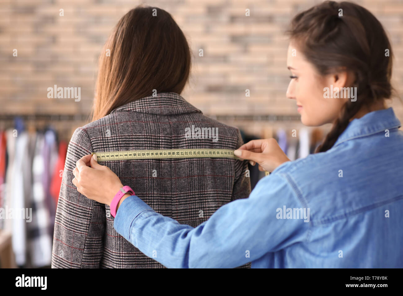 Junge weibliche individuell mit dem Kunden an der abschließenden Montage Arbeiten im Atelier Stockfoto