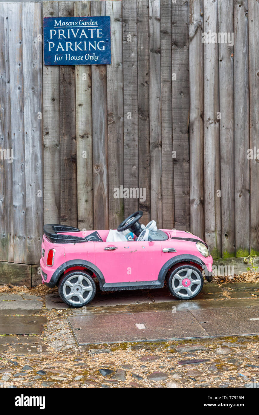 Humorvoll Bild von Spielzeug eines kleinen Kindes Auto unter Privater Parkplatz Schild geparkt. In Cambridge, England, UK gesehen. Stockfoto
