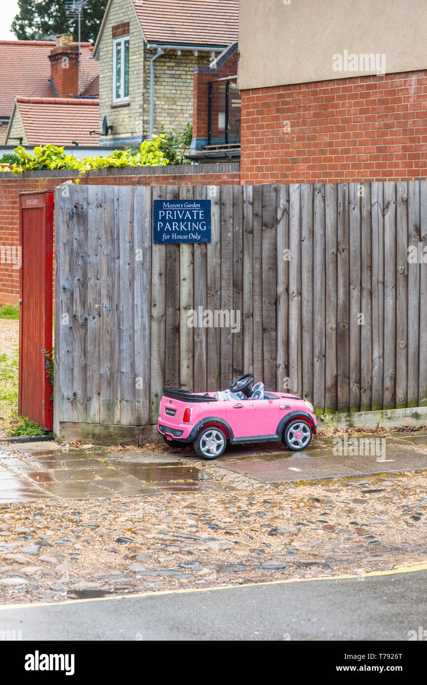 Humorvoll Bild von Spielzeug eines kleinen Kindes Auto unter Privater Parkplatz Schild geparkt. In Cambridge, England, UK gesehen. Stockfoto