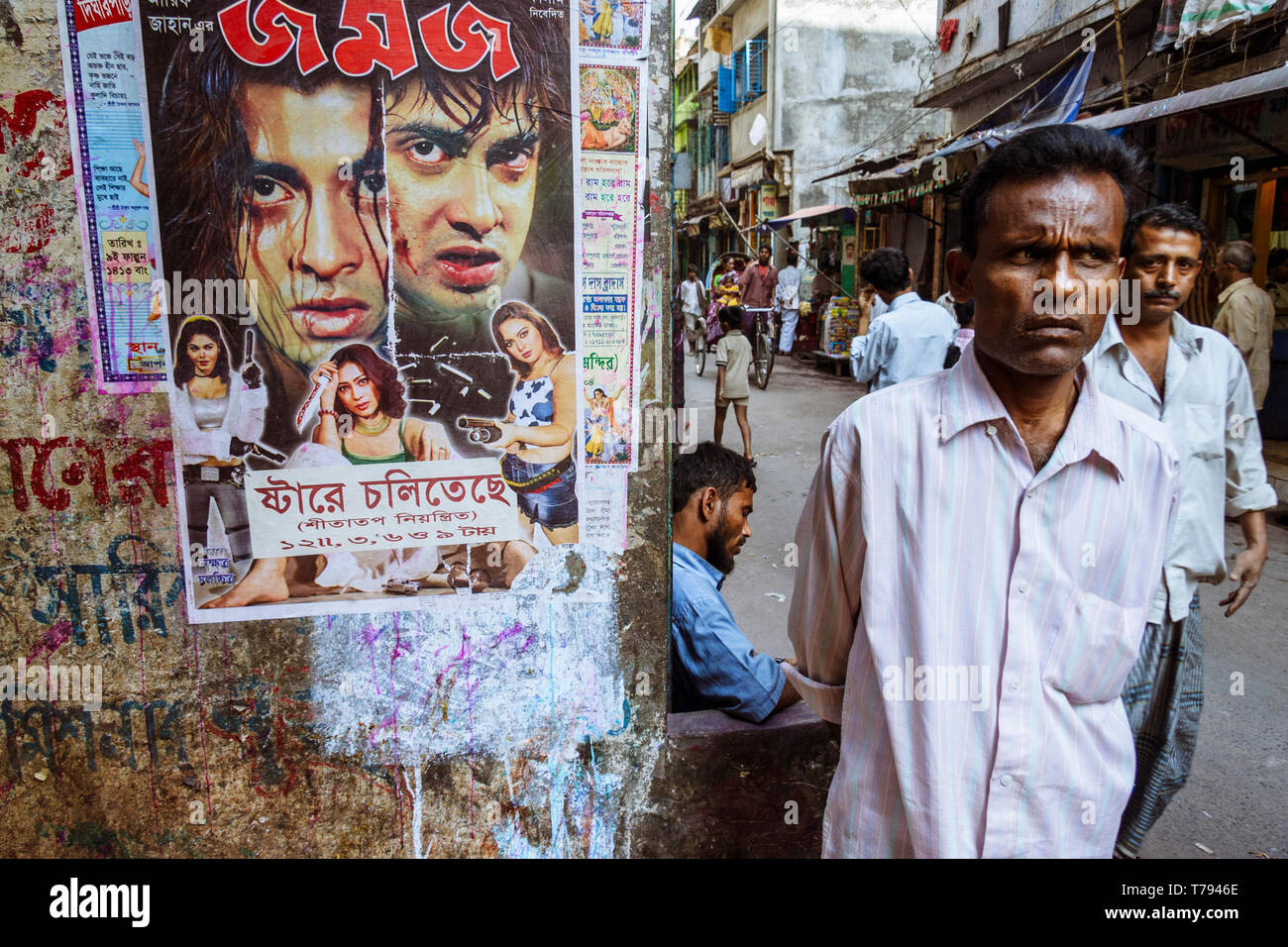 Dhaka, Bangladesch: Ein Mann steht eine Dhallywood (der bengalischen Filmindustrie) Film Poster in Shankhari Basar aka Hindu Straße eine der ältesten Stockfoto