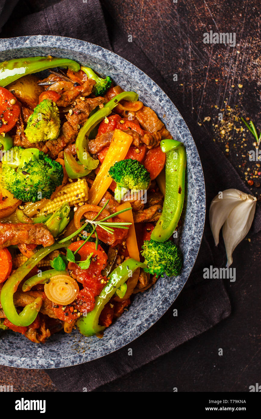 Fried Beef Stroganoff mit Kartoffeln, Broccoli, Mais, Paprika, Karotten und  Sauce in eine Pfanne, dunklen Hintergrund Stockfotografie - Alamy