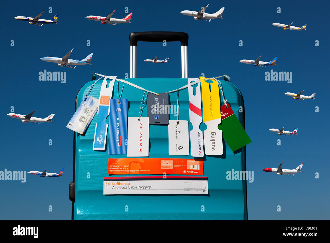 Trolley mit Handgepäck Tags verschiedener Airlines über einen blauen Himmel mit mehreren Flugzeugen Stockfoto