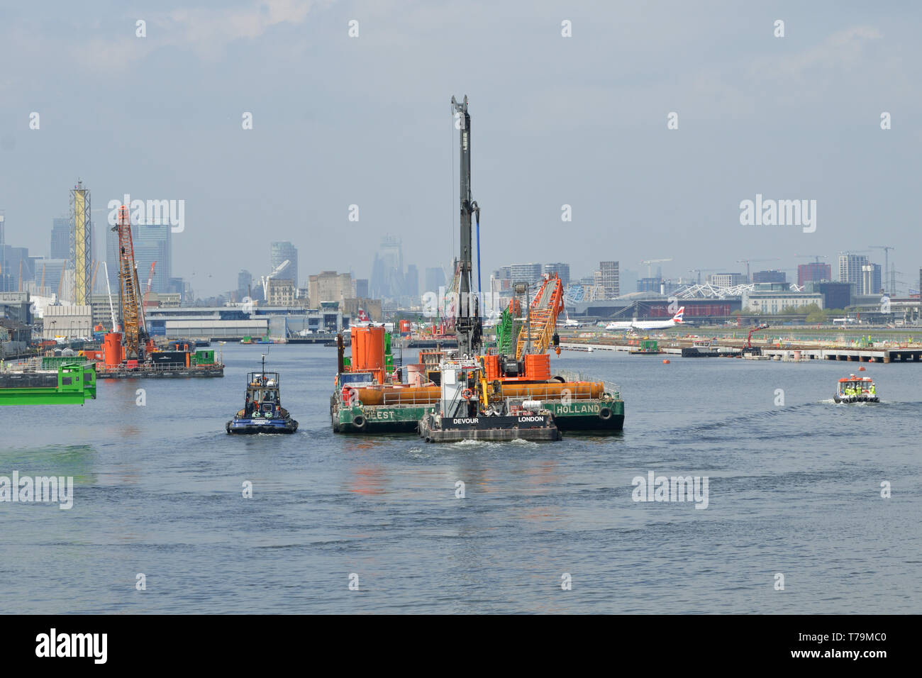 Schlepper bewegt ein Engineering barge in der King George V Dock, London, als Teil des London City Airport CADP Expansion arbeitet Stockfoto