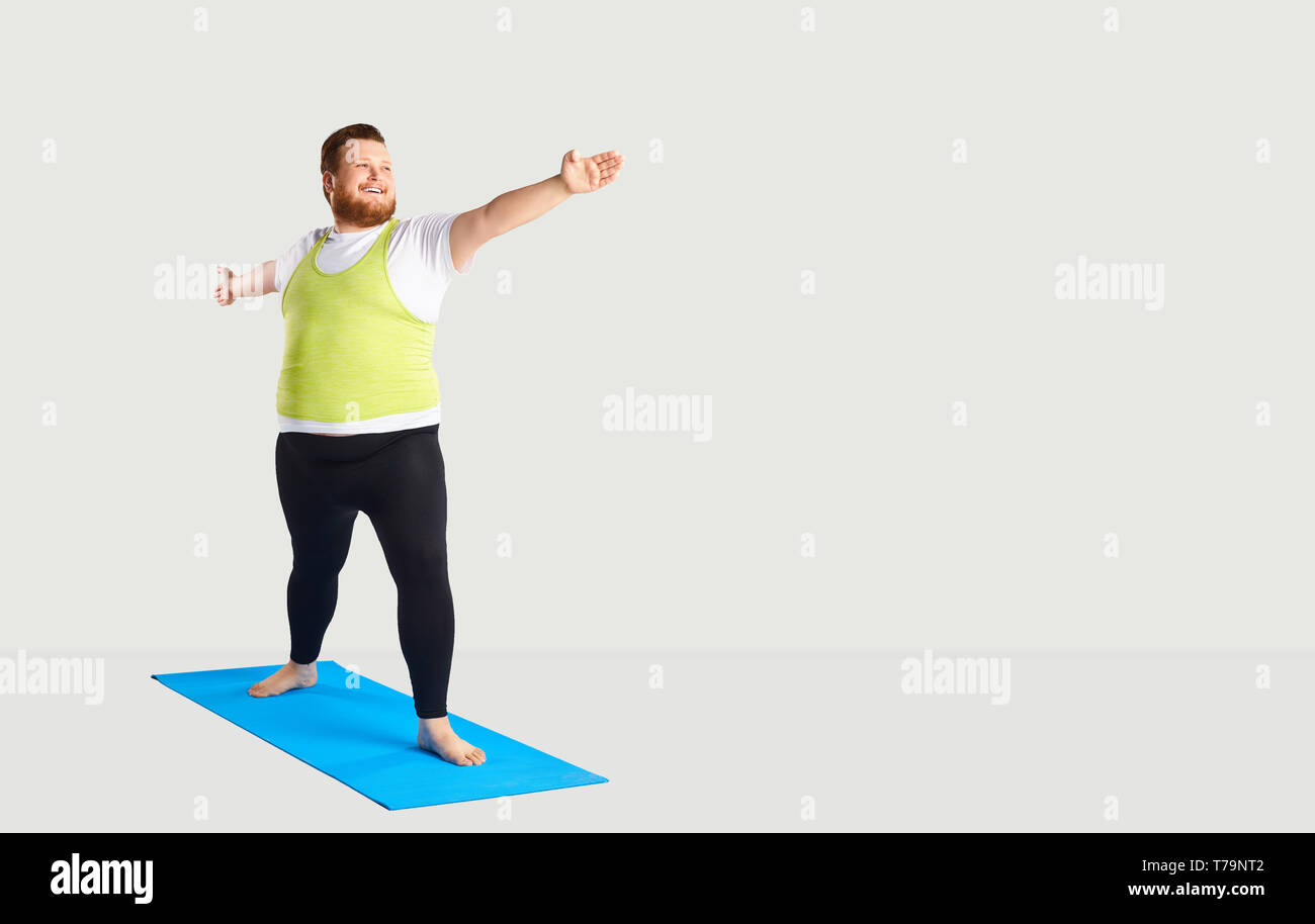 Fett lustige Mann Yoga auf grauem Hintergrund Stockfoto