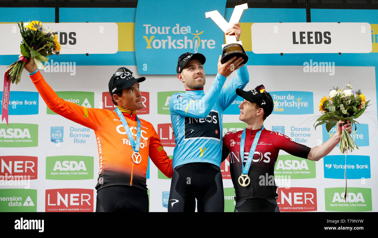 Tour de Yorkshire Sieger Team Ineos' Christopher Lawless (Mitte) feiert mit der Trophäe neben den zweiten Platz das CCC Team Greg Van Avermaet (links) und dritten Platz Team Ineos' Edward Dunbar (rechts) nach Stufe 4 der Tour de Yorkshire. Stockfoto