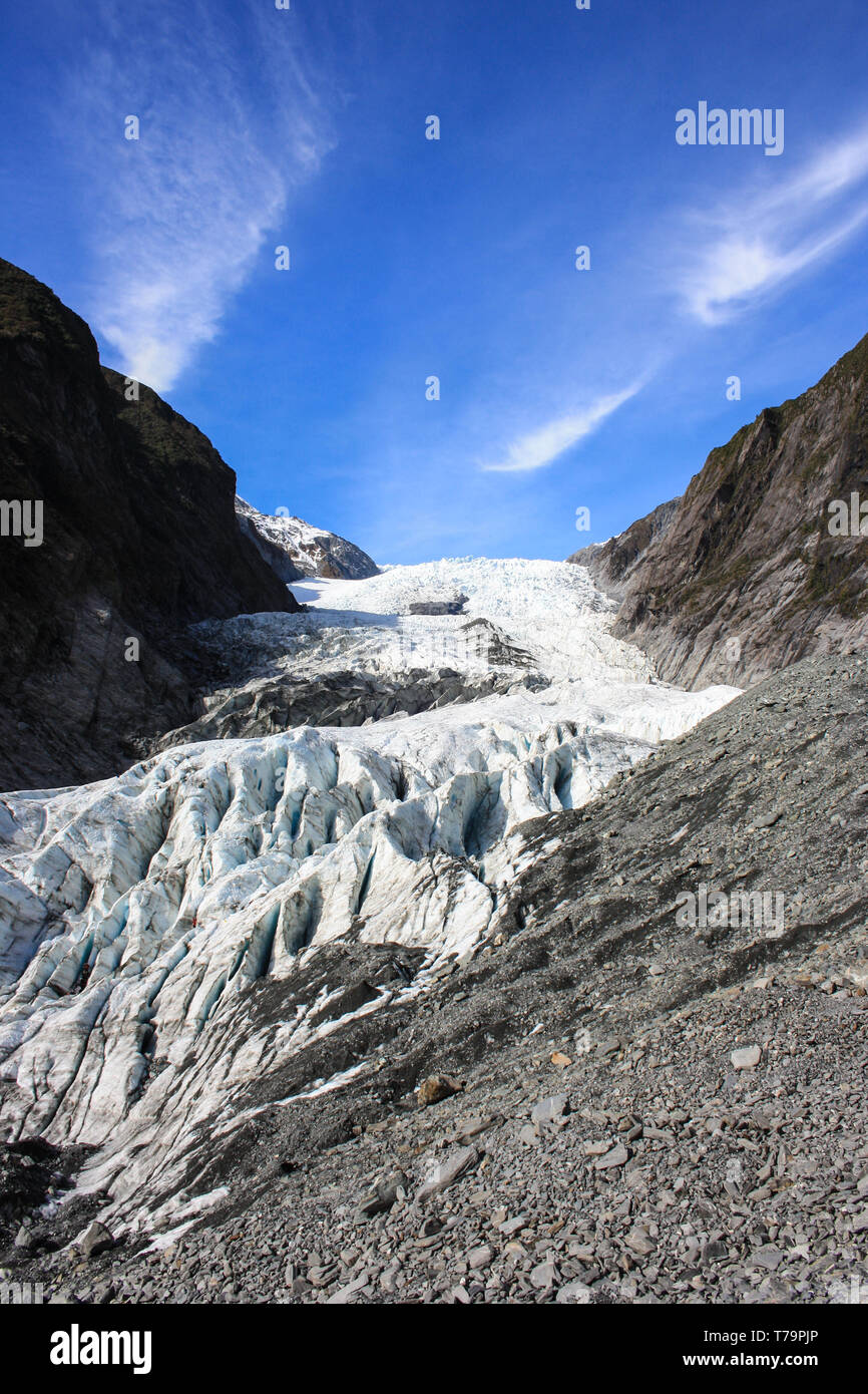 Blick auf den Franz Josef Gletscher, felsigen Aufstieg mit einigen grünen Vegetation auf beiden Seiten, an der Westküste der neuseeländischen Südinsel. Stockfoto