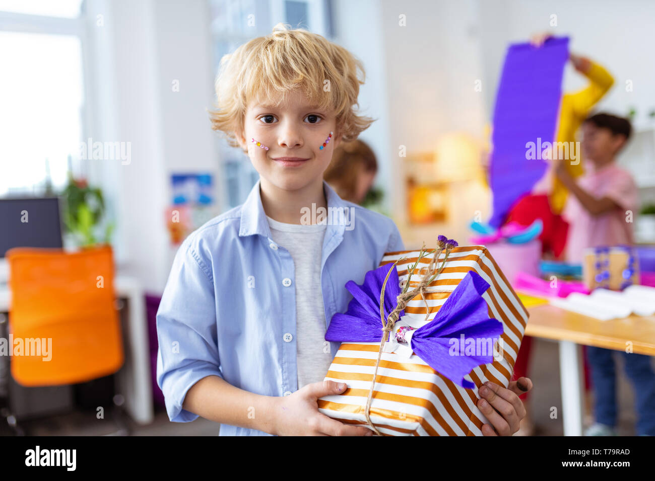 Big vorhanden. Blond dark-Eyed Handsome Schüler zeigen großes vorhanden, nachdem verzieren es Stockfoto