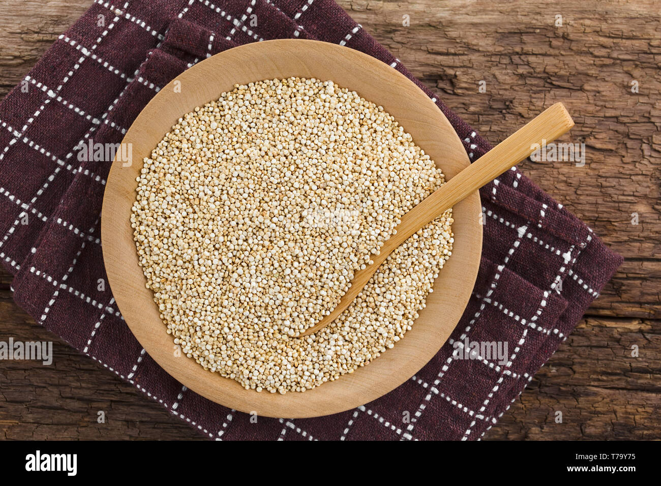 Rohweiß Quinoa Samen (lat. Schisandra Quinoa) auf Holzplatte mit Holzlöffel, fotografiert Overhead (selektive Fokus, Fokus auf der Quinoa) Stockfoto