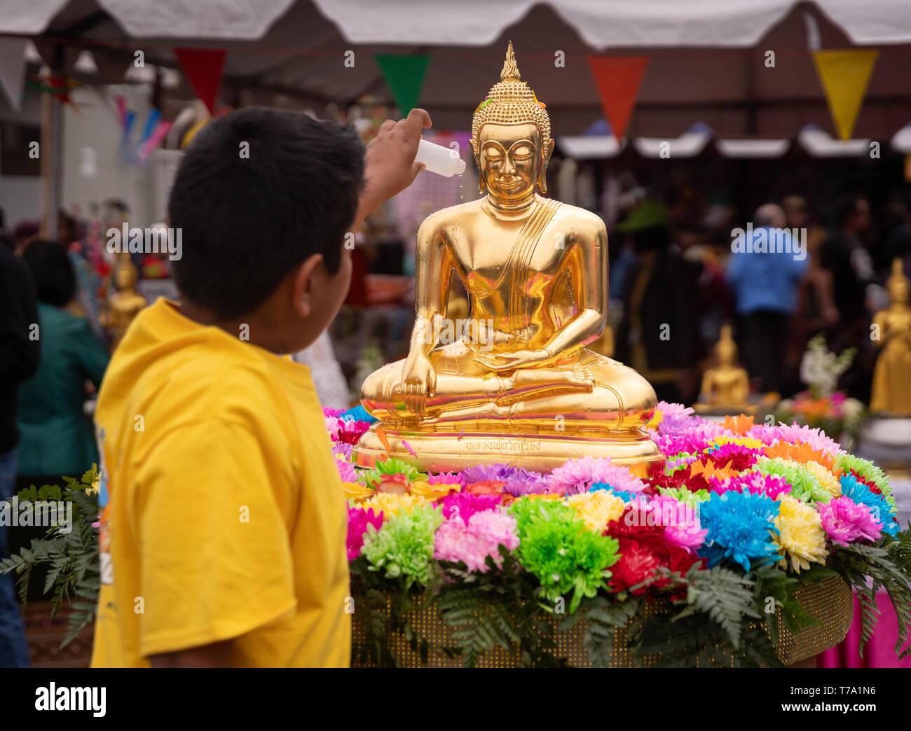 Das streuen Blumen duftende Wasser über buddhistische Statue während Songkran Festival feiert das Thai Neujahr, in Los Angeles, Kalifornien. Stockfoto