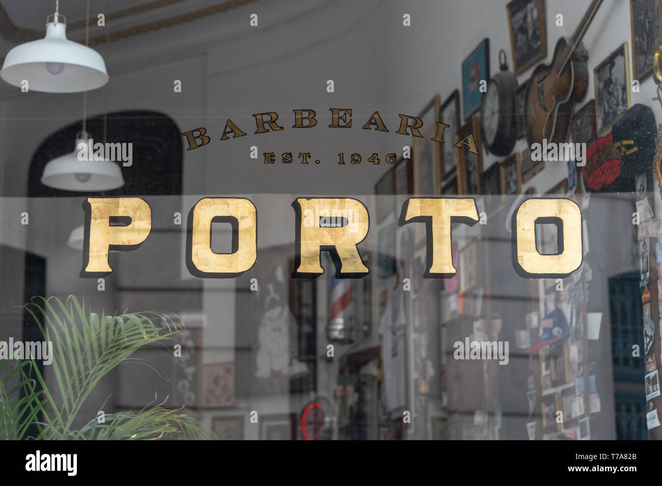 Gold Porto Zeichen im Fenster eines traditionellen barbershop​ es das Zentrum der Stadt. Stockfoto