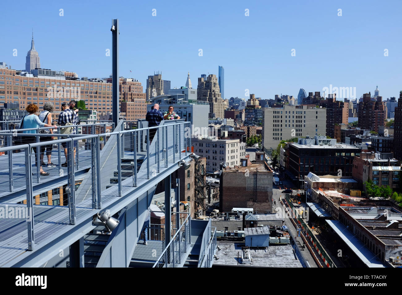 Besucher auf Treppen im Außenbereich und auf der Terrasse des Whitney Museum für amerikanische Kunst mit Meatpacking und Chelsea Bezirk im Hintergrund. New York City, USA. Stockfoto