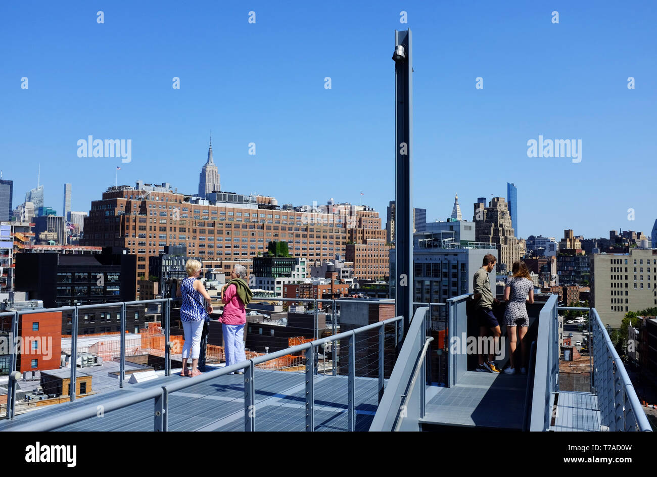 Besucher auf Treppen im Außenbereich und auf der Terrasse des Whitney Museum für amerikanische Kunst mit Meatpacking und Chelsea Bezirk im Hintergrund. New York City, USA. Stockfoto