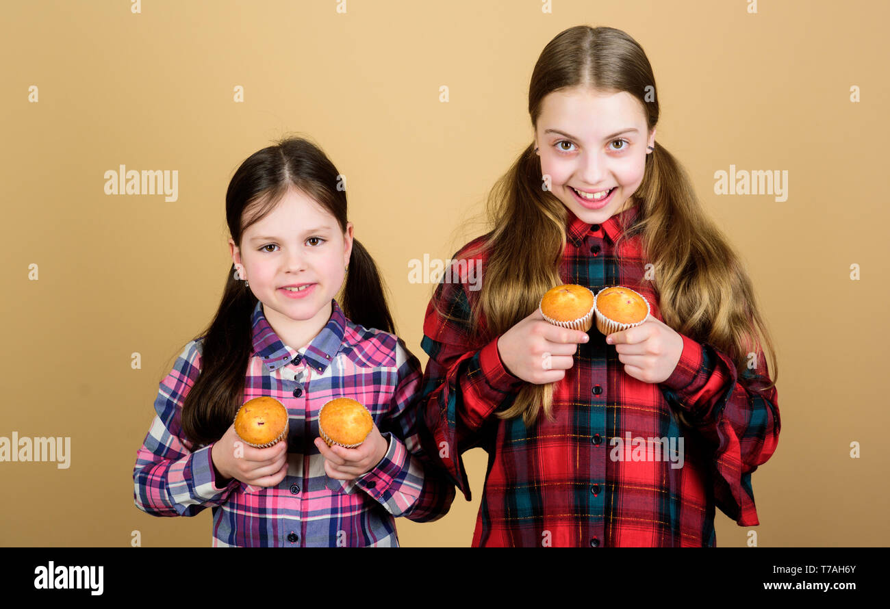 Muffin kämpfen. Kleine Kinder glücklich lächelnd mit quickbread Muffins. Glückliche kleine Mädchen backen Frühstück Muffins zu Hause. Genießen Sie Ihre bevorzugten muffin Flavour. Stockfoto