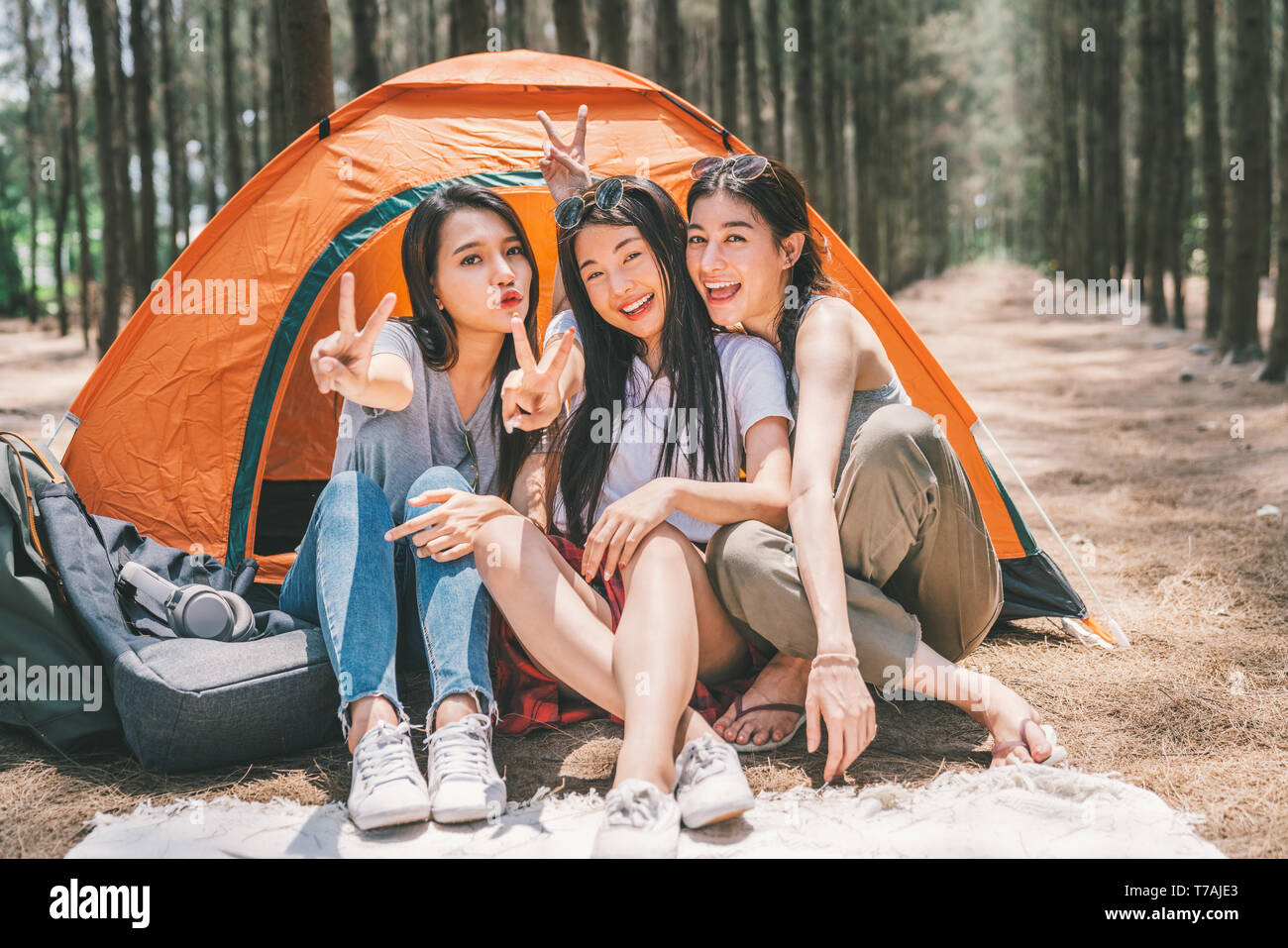 Gruppe der glücklichen asiatischen Mädchen im Teenageralter dabei Sieg zusammen stellen, Camping, das sich vom Zelt. Aktivität im Freien, Abenteuer Reisen oder Urlaub Konzept Stockfoto