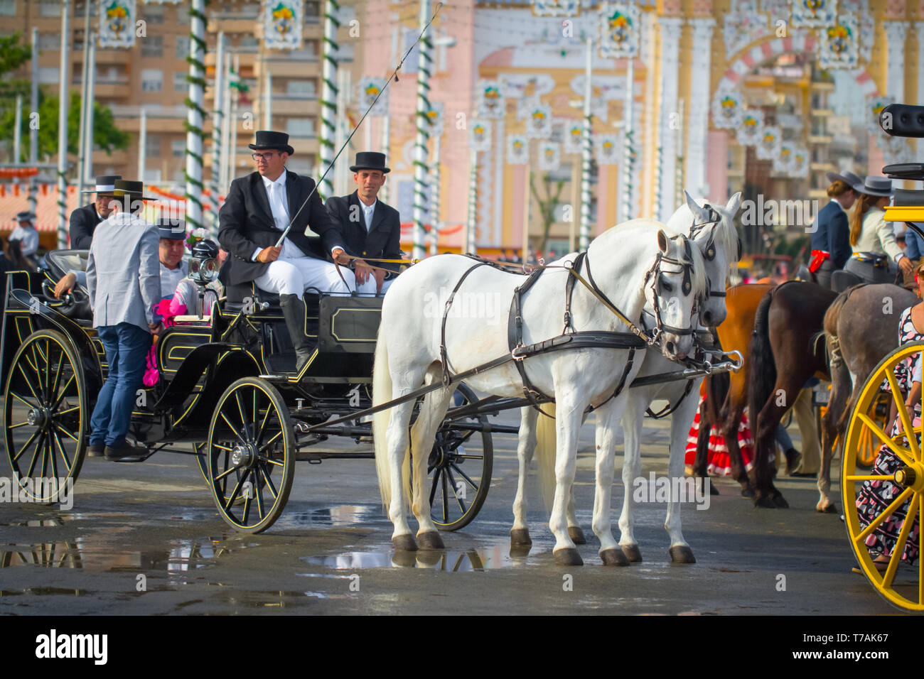 Sevilla, Spanien - APR, 2014: Menschen in traditionellen Kostümen auf Pferdewagen in Sevilla, Spanien Stockfoto