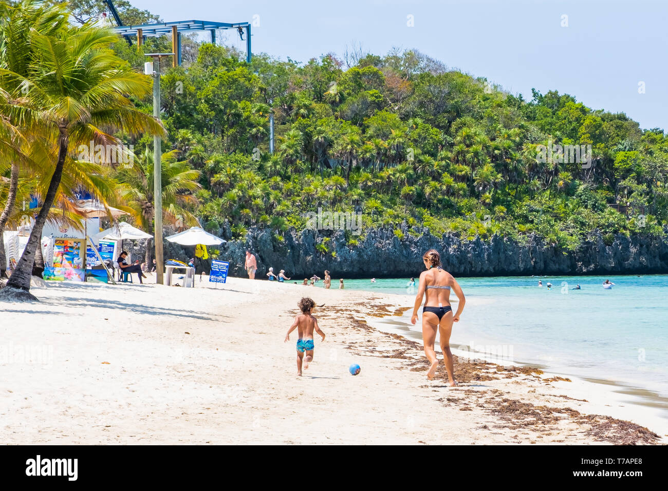 Mutter und Sohn spielen Fußball Fußball am West Bay Beach Roatan Honduras. Stockfoto