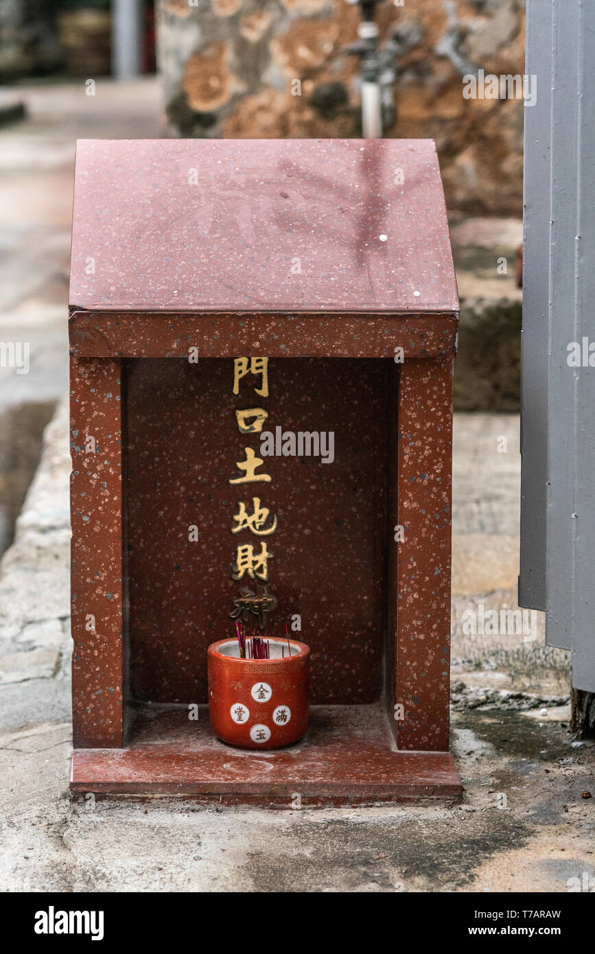 Hong Kong, China - 7. März 2019: das Fischerdorf Tai O. Freistehende kleine private Taoistischen Heiligtums vor dem Haus im Flügel auf der Straße. Vor allem Braun eine Stockfoto