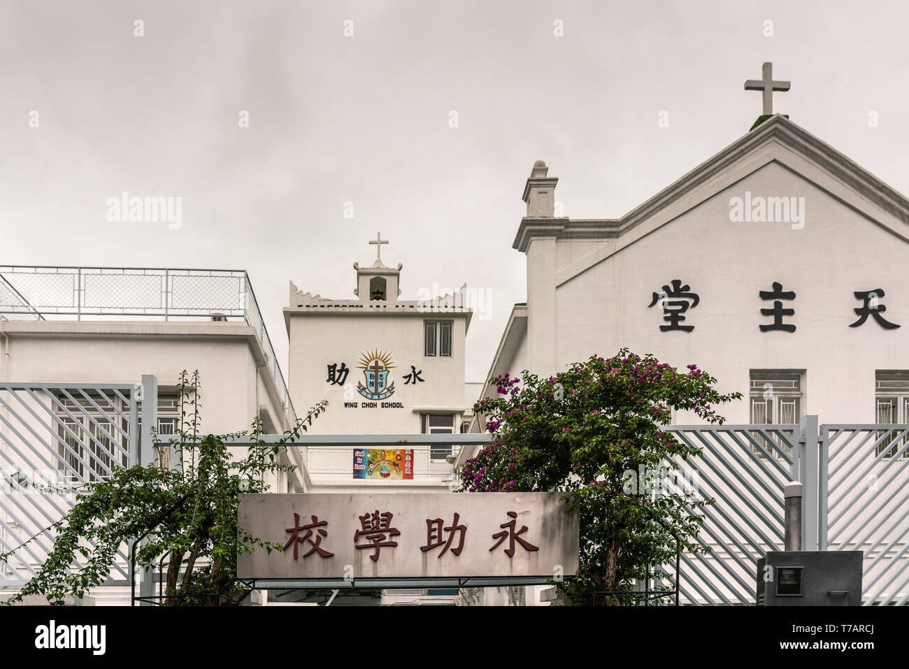 Hong Kong, China - 7. März 2019: das Fischerdorf Tai O. Das weiße Gebäude ist Wing Choh Grundschule, und die Katholische Kirche der Muttergottes von der Immerwährenden Hilfe Stockfoto