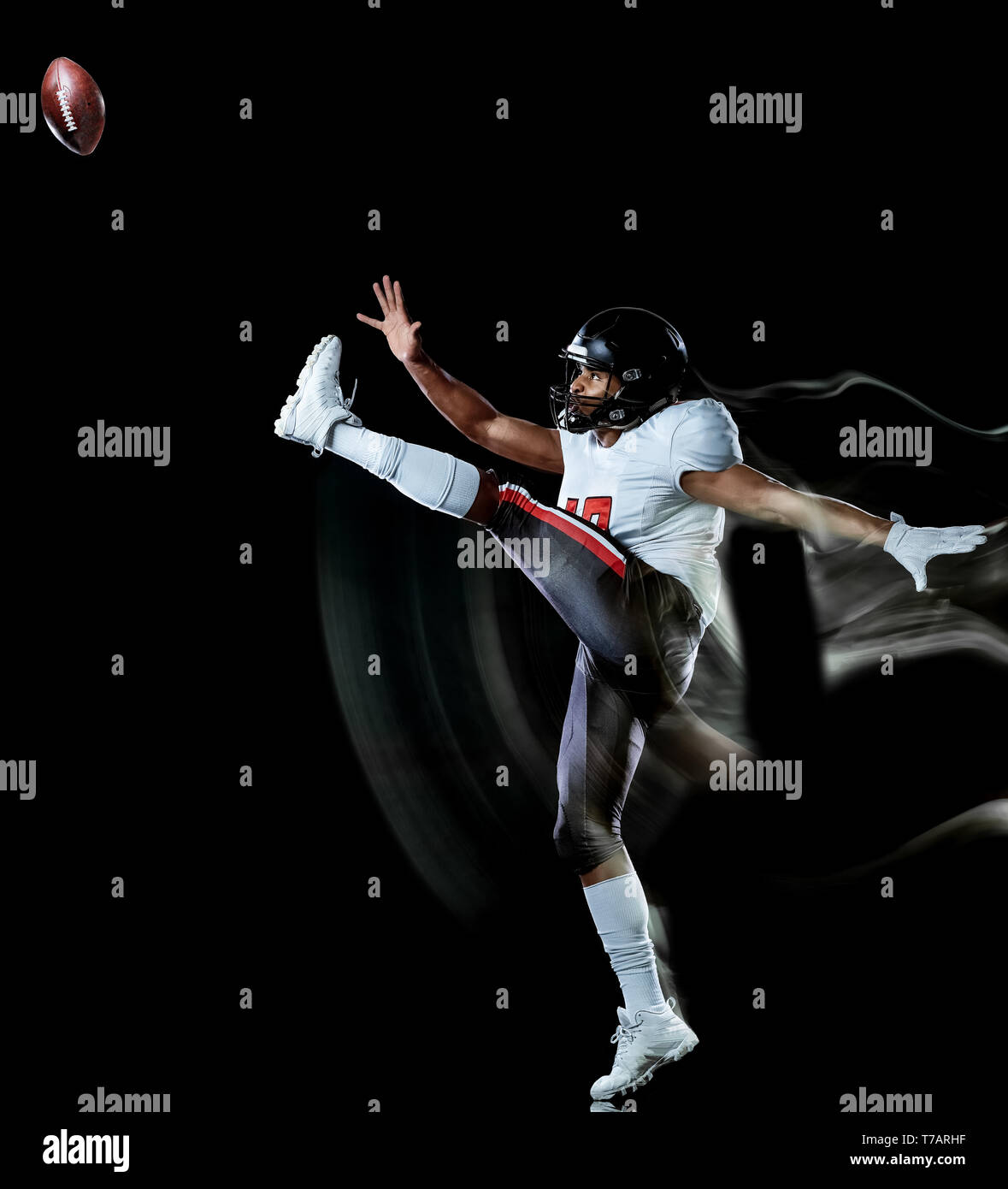 Ein afrikanischer Fußballspieler Mann studio Schuß auf schwarzen Hintergrund mit Licht malen mit unscharfen Bewegungsgeschwindigkeit Effekt isoliert Stockfoto