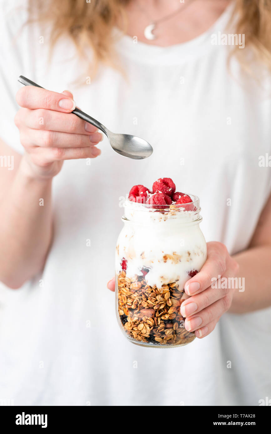 Mädchen, dass Jar mit gesunden Frühstück Parfait von Joghurt mit granol und Himbeeren in den Händen. Konzept der gesunden Ernährung, gesund leben, Diät Stockfoto