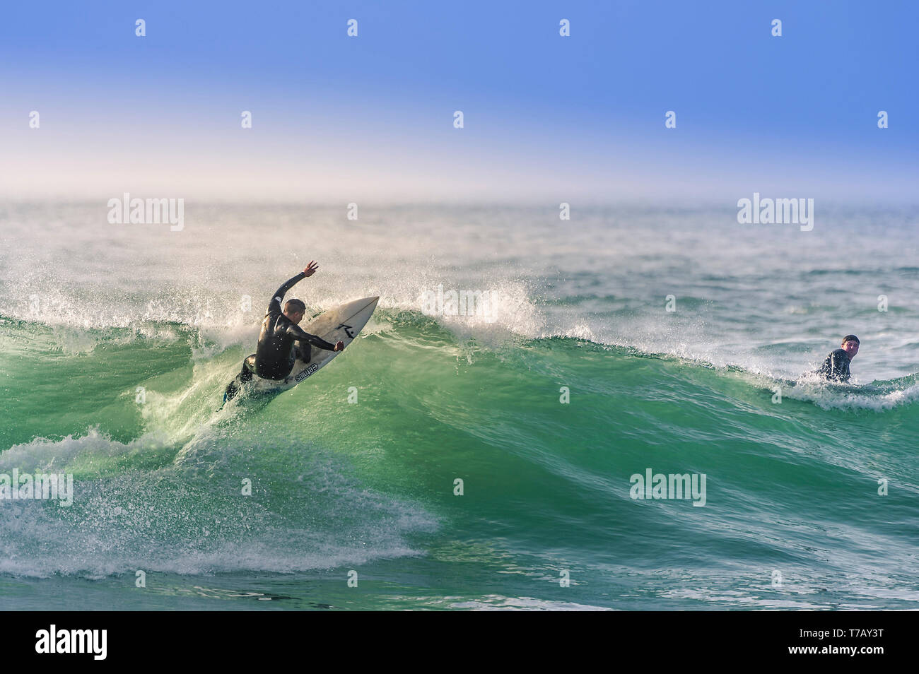Ein surfer Carving eine Welle an den populären Surfen hotspot Fistral Beach in Newquay in Cornwall. Stockfoto