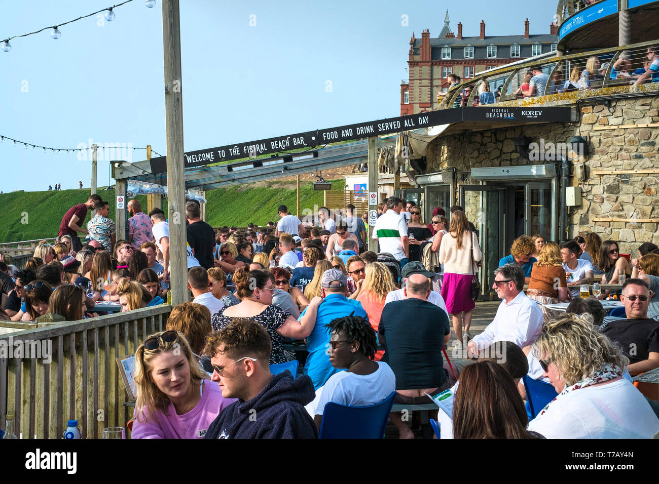 Urlauber sitzen und plaudern Am Fistral Beach Bar in Newquay in Cornwall. Stockfoto