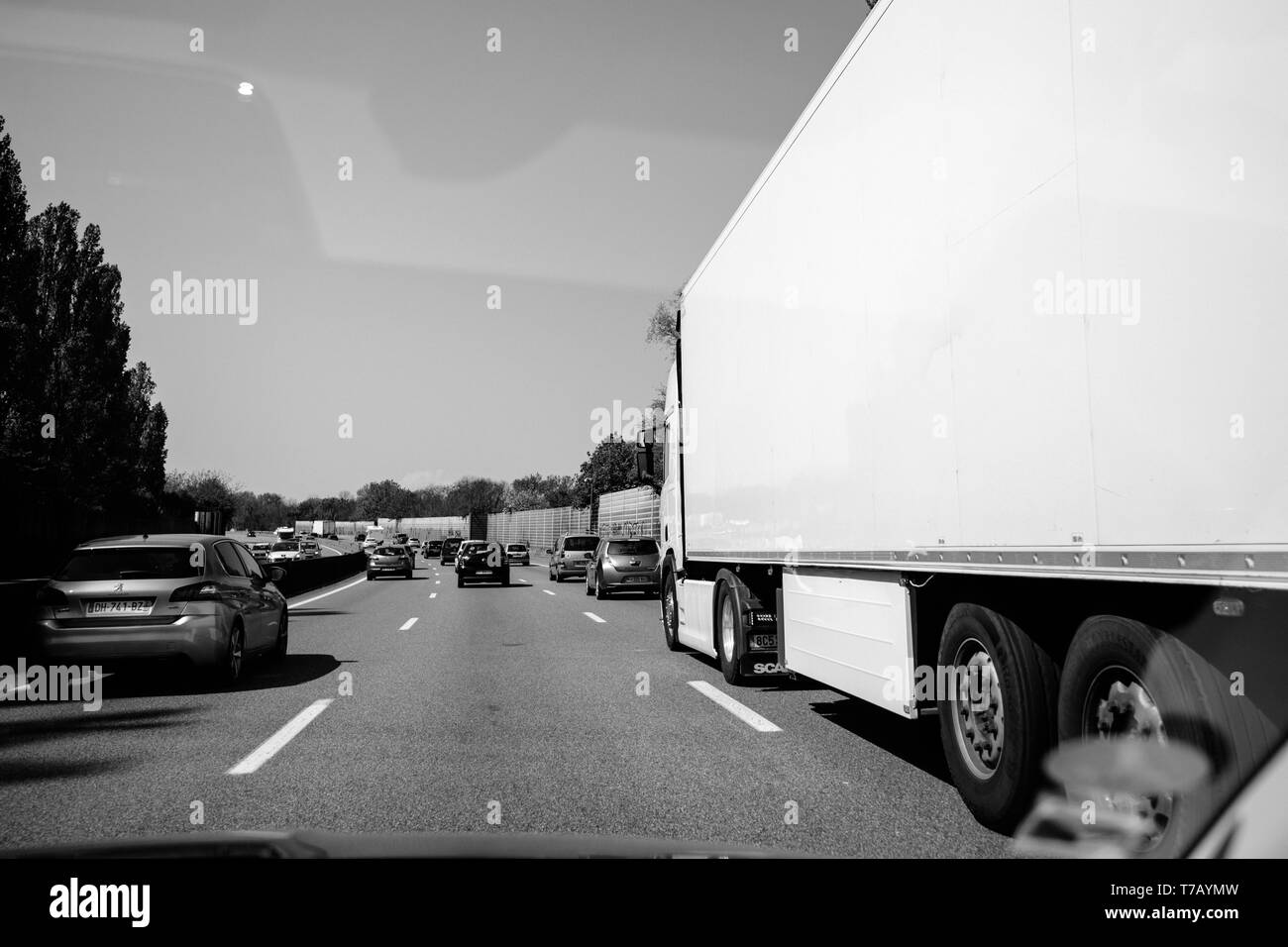 Frankreich - Apr 19, 2019: Schwarz und Weiß moderater Verkehr auf der französischen Autobahn Perspektive am langen Autobahn mit Pkw, Lkw und SUV Stockfoto