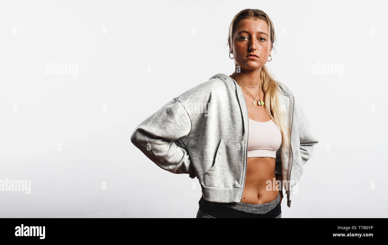 Porträt eines Fitness Frau gegen weißen Hintergrund auf den Bund. Weibliche Athleten mit Eine gebräunte Haut an Kamera schaut. Stockfoto