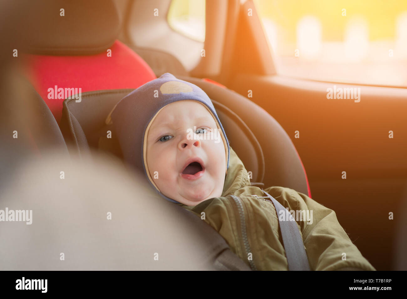 Süßes kleines Kind schlafen im Auto mit Sicherheitsgurt für Sicherheit  während der Reise befestigt Stockfotografie - Alamy