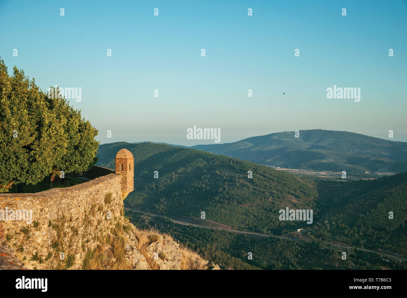 Kleine Wachtturm und stein Wand über felsige Klippe mit hügeligen Landschaft auf dem Sonnenuntergang in Ohrid. Eine mittelalterliche Weiler thront auf einem Felsen in Portugal. Stockfoto