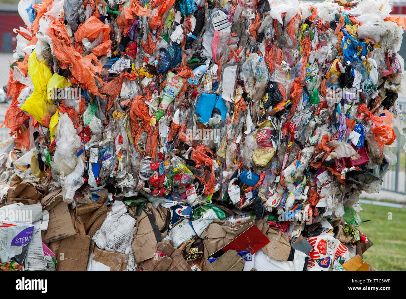 Abfalltrennung mit verschiedenfarbigen Plastiktüten. Ballen gepresstem Kunststoff als resurce Stockfoto