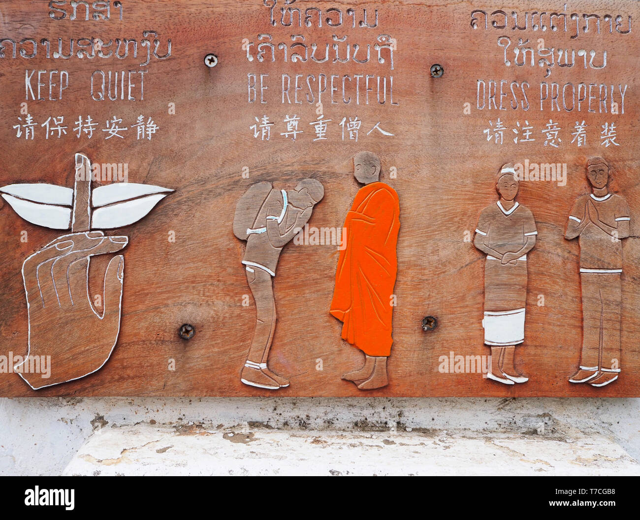 Regeln auf einem Schild vor einem buddhistischen Tempel in Luang Prabang in Laos. Ruhig halten. Respektvoll. Kleid richtig. Stockfoto