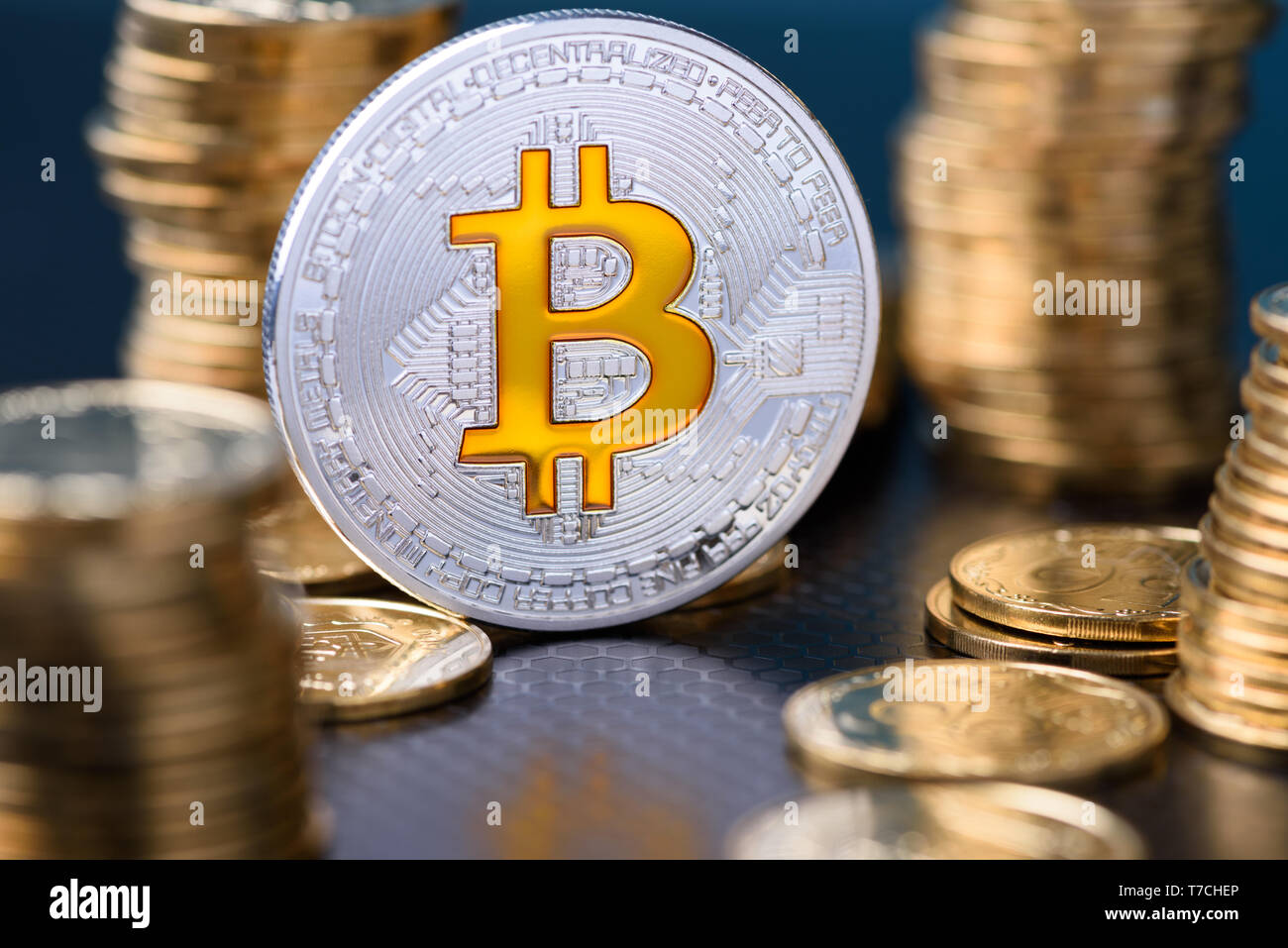 Bitcoin. Silber bitcoin Münze zwischen goldenen Münzen Stapeln mit  Reflexion Stockfotografie - Alamy