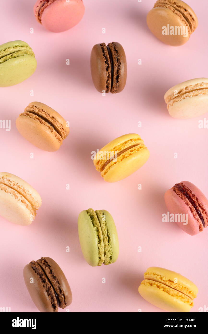 Klassische bunte Französische macarons Sortiment mit verschiedenen Geschmacksrichtungen auf Rosa pastell Hintergrund Stockfoto