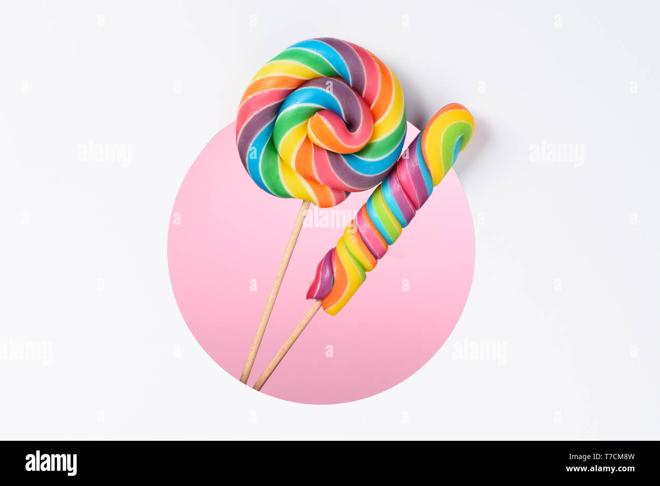 Lutscher Bonbons bunte Regenbogen in einer mehrschichtigen Papier Design mit Kreis schneiden Loch rosa Hintergrund und kopieren Raum Stockfoto
