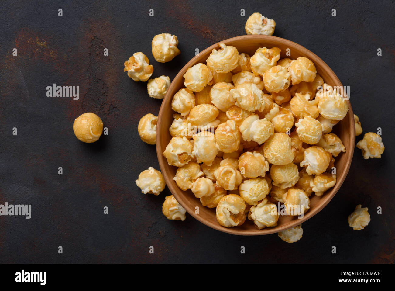 Karamell Popcorn in der Schüssel auf dunklen Tisch Hintergrund Stockfoto