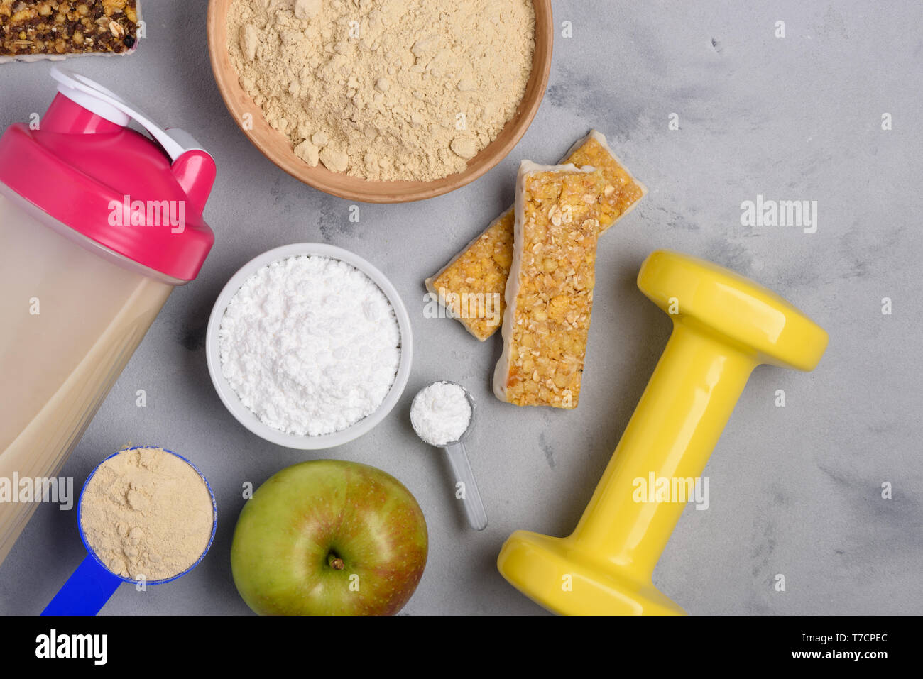 Sport Ernährung Vegetarische Protein Pulver, Creatin mit Snacks und Hantel auf konkreten Hintergrund der Ansicht von oben flach Stockfoto
