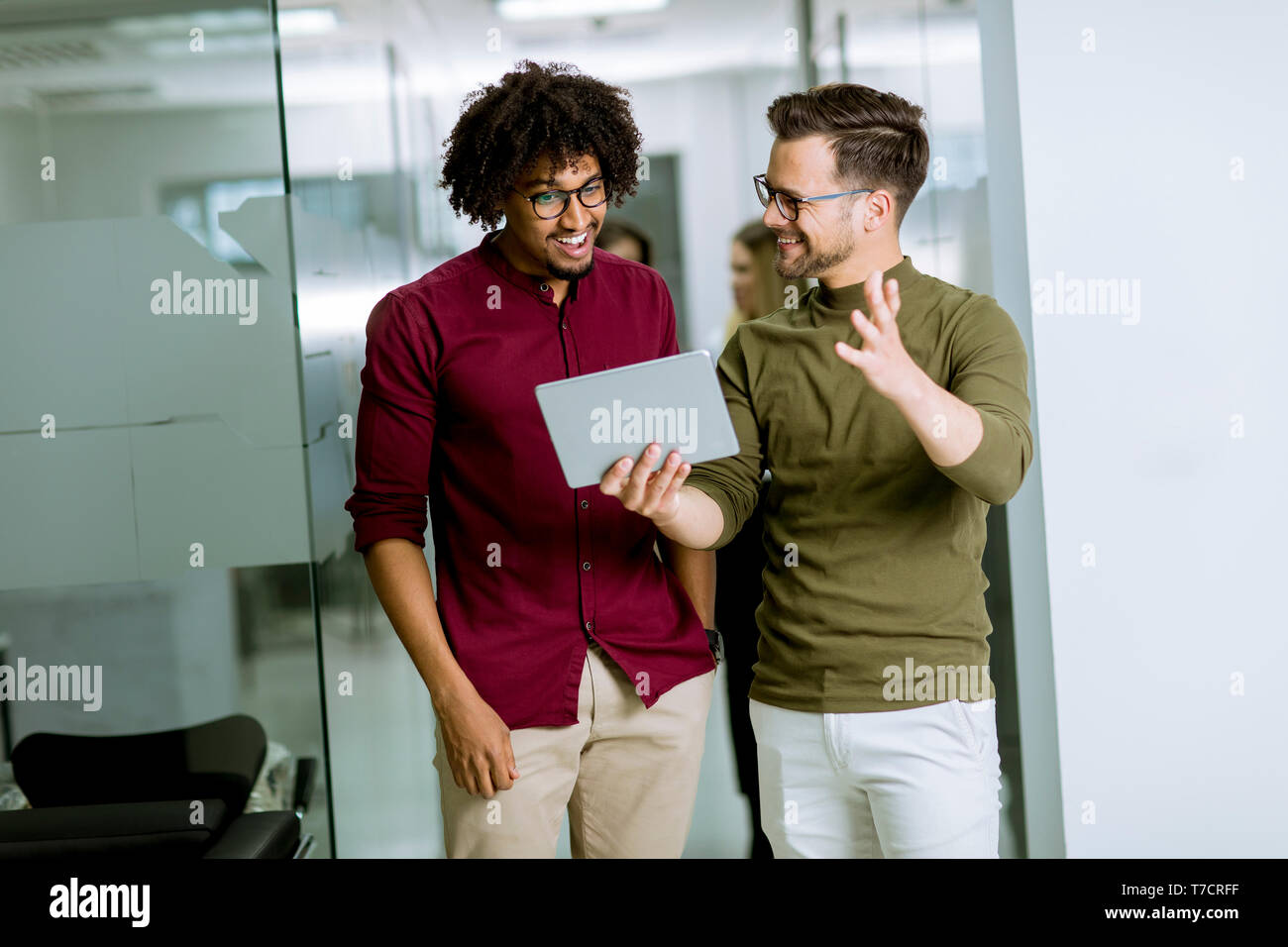 Jungen multiethnischen Geschäftspartner mit einem digitalen Tablet im Büro Stockfoto