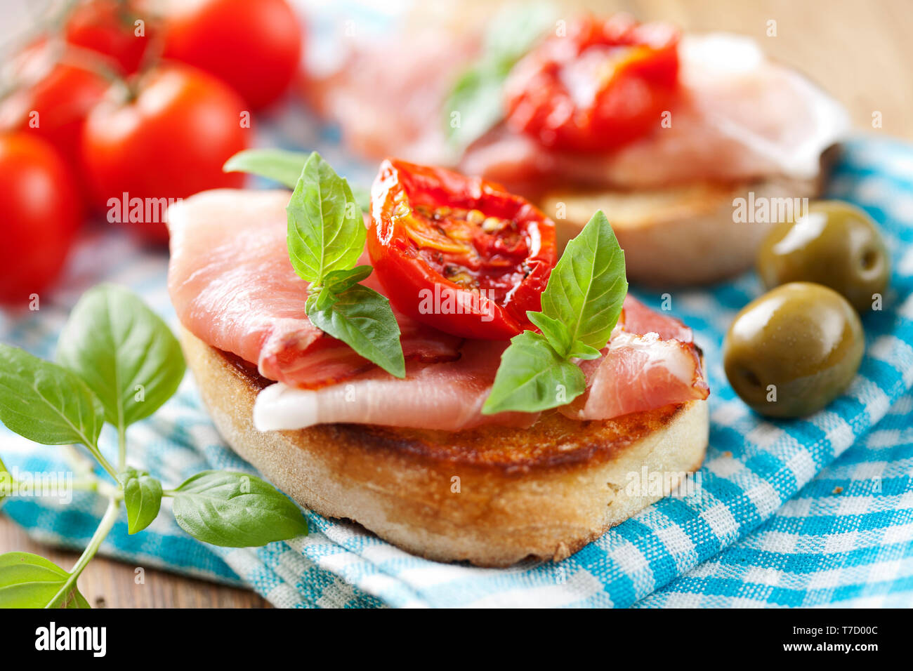 Crostini mit Parmaschinken und getrocknete Tomaten und Basilikum Stockfoto