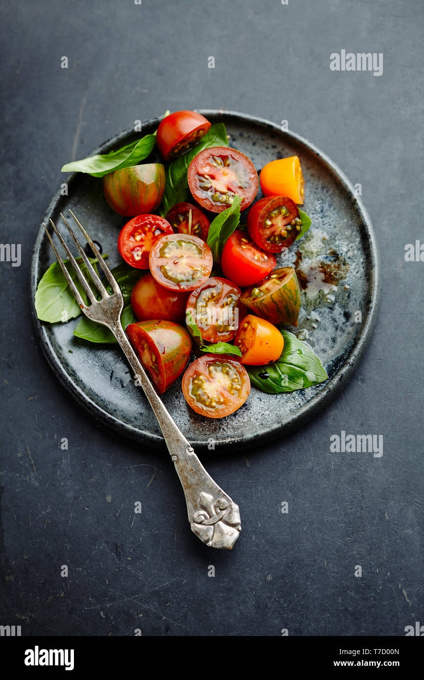 Rustikale Tomatensalat mit Mischformen, frischem Basilikum, Balsamico und Olivenöl Stockfoto