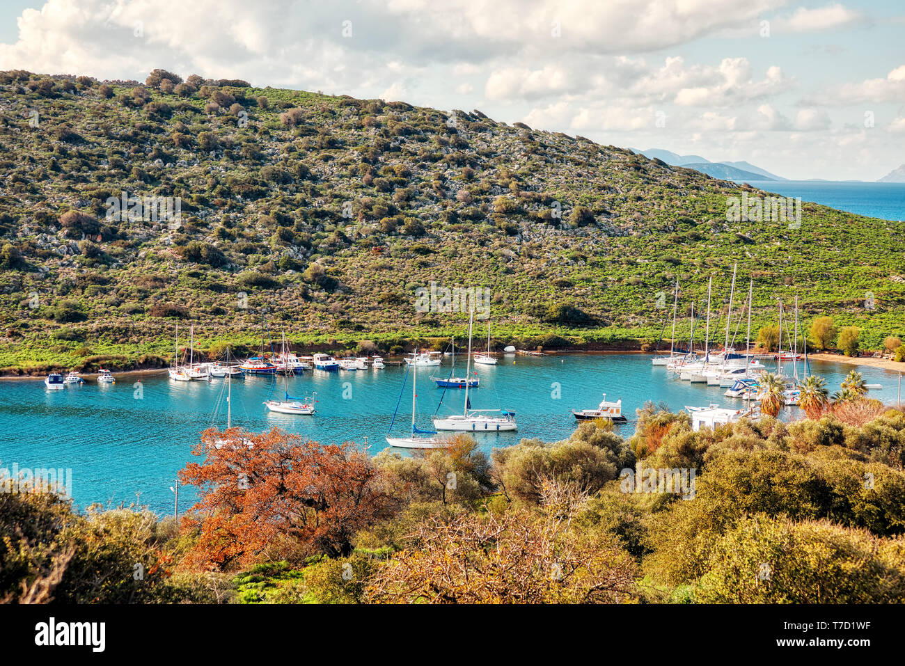 Yachten und Boote über das ruhige türkisfarbene Meer an gumsuluk Bucht in Bodrum, Mugla, Türkei verankert. Stockfoto