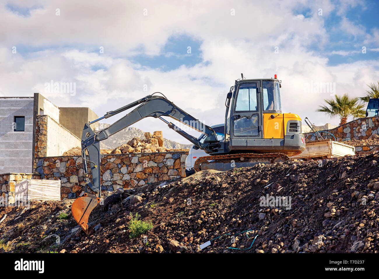 Earth mover Bagger über den Hügel zu einem Immobilien Bau Baustelle geparkt Stockfoto