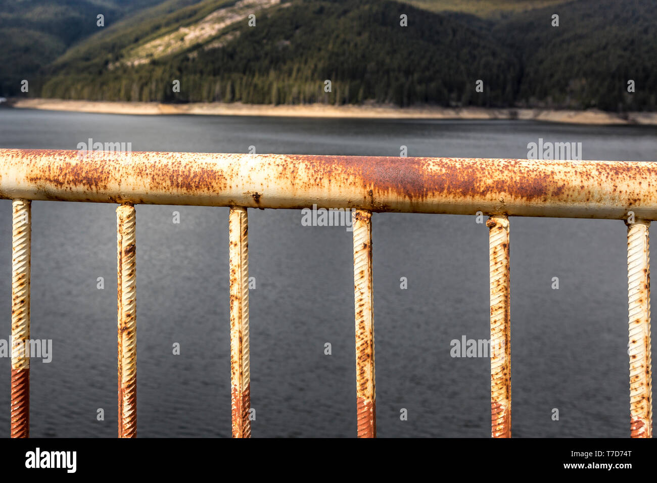 Rostige Geländer gegen Mountain Lake Stockfoto