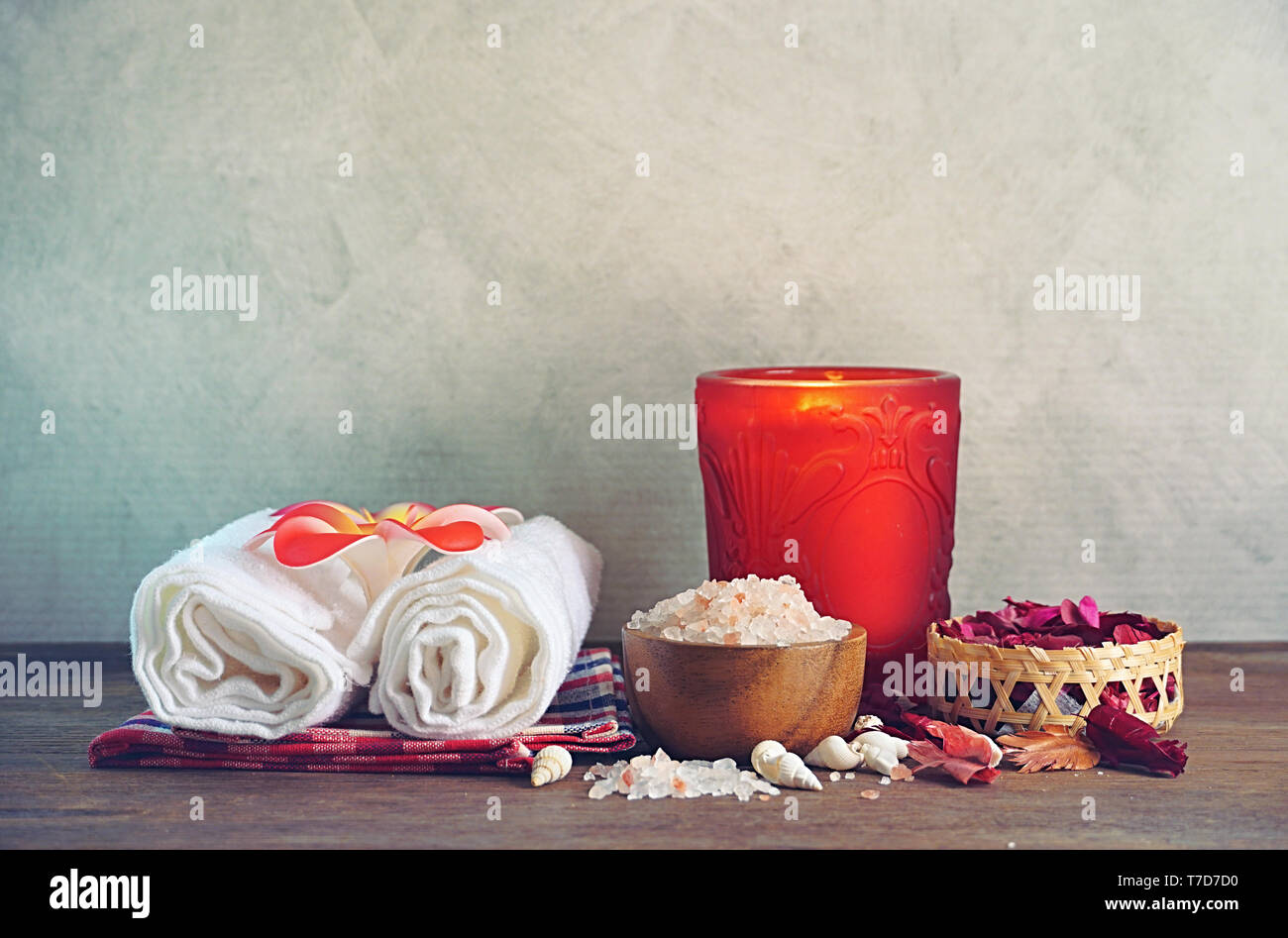 Himalaya Salz mit Handtuch und Aroma Kerze verzieren mit trockenen Rosen auf Holz Tisch für Peeling spa Therapie. Stockfoto