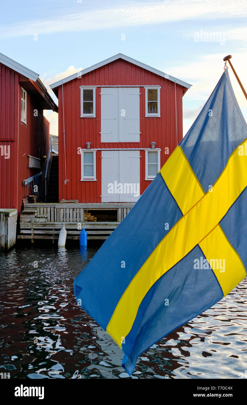 Eine rot lackierte Angeln Kabine und die schwedische Flagge in Smogen auf der Bohuslan Küste in Schweden Stockfoto