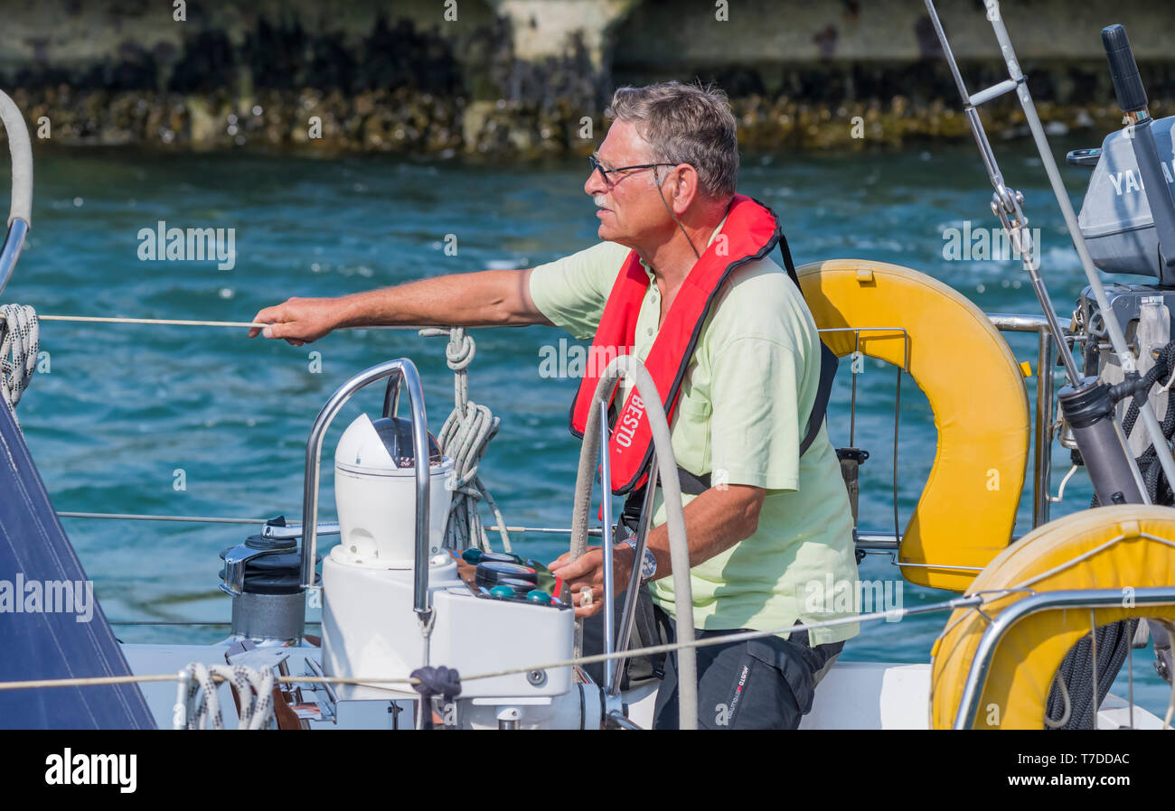 Im mittleren Alter Mann Lenkung einer Yacht. Stockfoto